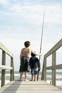 dam-migration-miss/md_MKjrWTWJgH01.jpg Two young boys standing on the edge of a wooden pier looking out at the sand and water.